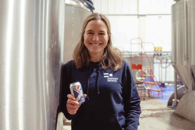 Sonja Mitchell, founder of Jump Ship Brewing holding a can of Jump Ship beer 